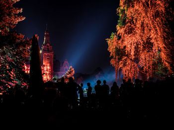 Silhouette of people at illuminated building at night