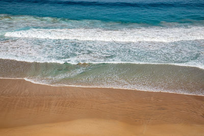 High angle view of waves rushing towards shore