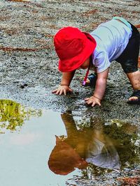 Reflection of boy standing in puddle