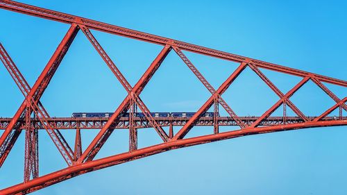 Low angle view of suspension bridge against clear blue sky