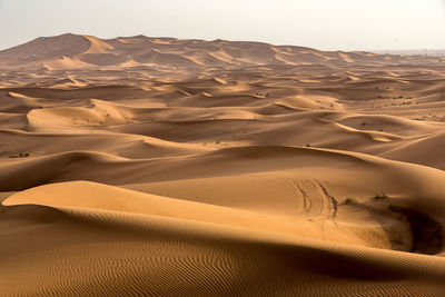 Scenic view of sand dunes in desert against sky