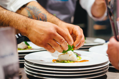 Cropped image of chef preparing seafood in plate at restaurant