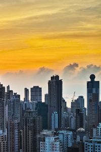 View of cityscape against cloudy sky during sunset