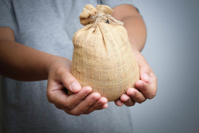 Midsection of man holding jute sack