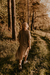 Rear view of woman standing on field