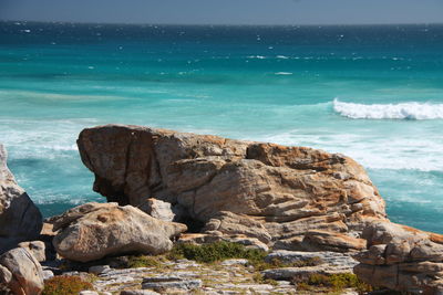 Rocks on sea shore against sky