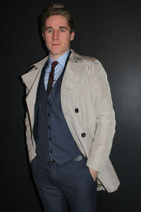 Portrait of handsome businessman standing with hands in pockets against black background