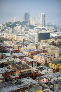 Aerial view of buildings in city against sky