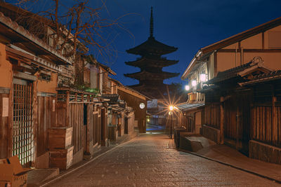 Street amidst buildings against sky at night