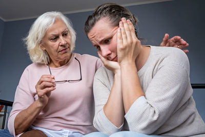 Portrait of young woman sitting on sofa at home