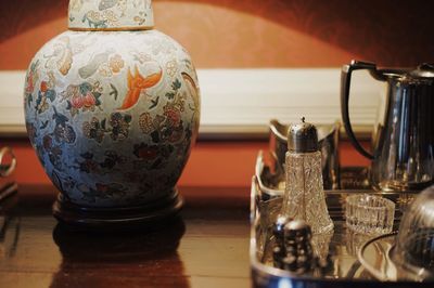 Close-up of utensil by illuminated lamp on table