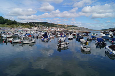 Boats moored in lake against sky in city