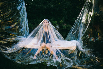 Woman covered in plastic on field