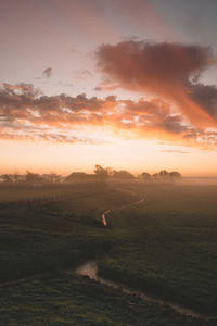 Scenic view of field against sky at sunset