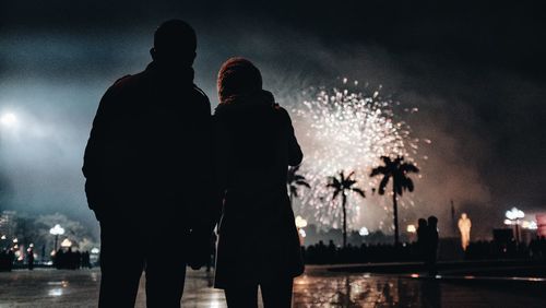 Silhouette of people standing at night