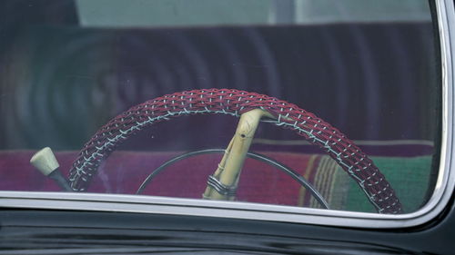 Close-up of bicycle by glass window