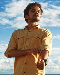 Low angle view of young man against sky