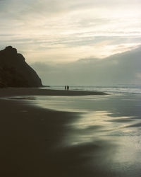 People on the beach during sunset. monte clerigo, algarve, portugal. expired kodak portra 160. 