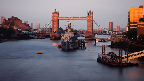 Boat on thames river against tower bridge in city