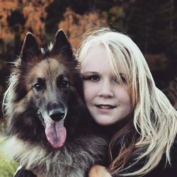 Close-up portrait of young woman with german shepherd