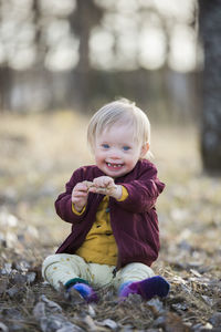 Portrait of cute girl sitting on field