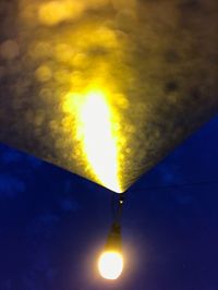 Low angle view of illuminated lamp against sky at night