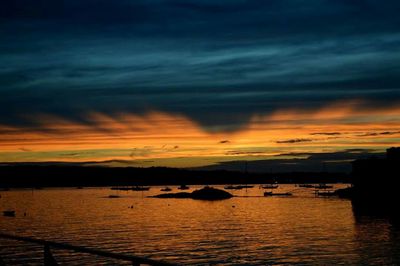 Scenic view of sea against cloudy sky at sunset