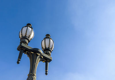 Low angle view of street light against blue sky