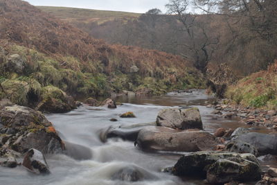 Idyllic rural scene with boulders in flowing stream