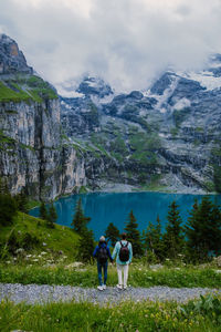 Rear view of people on mountain against sky