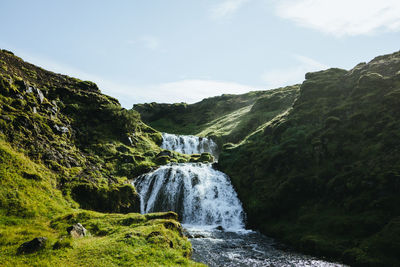 Scenic view of waterfall against sky