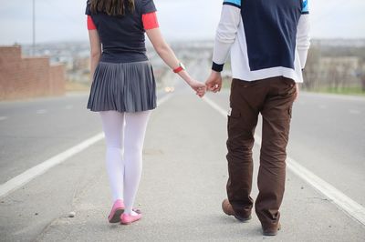 Rear view of couple holding hands