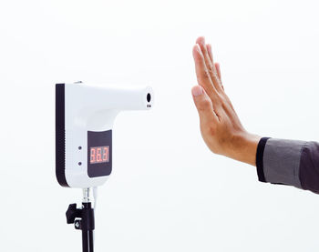 Low section of man photographing against white background