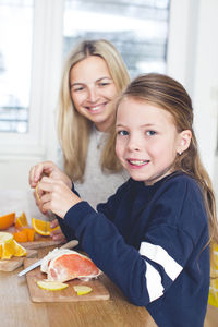 Portrait of happy mother and daughter at home