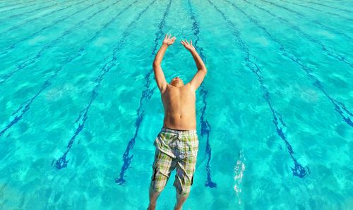 High angle view of man jumping in swimming pool