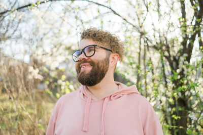 Close-up of young man against trees