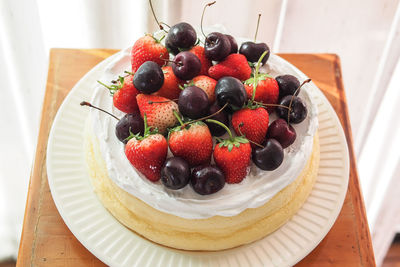 High angle view of fruits on cake at stool