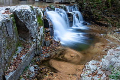 High angle view of young woman standing against waterfall