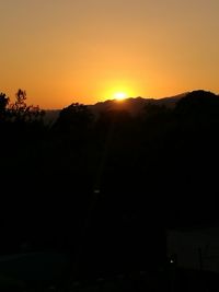 Scenic view of silhouette mountains against orange sky