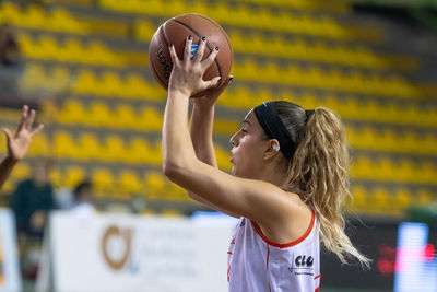 Rear view of woman with arms outstretched against blurred background