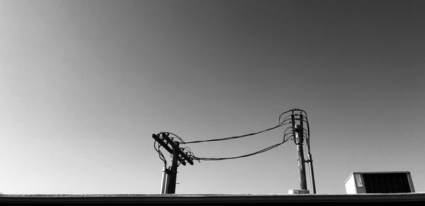 Low angle view of silhouette crane against clear sky