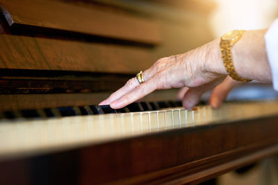 Cropped hand of woman playing piano