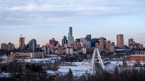 Modern buildings in city against sky during winter