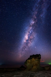 Scenic view of rock formation against sky at night