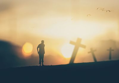 Silhouette man standing against sky during sunset