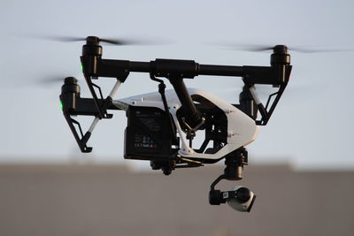 Close-up of camera hanging against sky