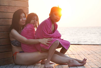 Side view of woman sitting at beach