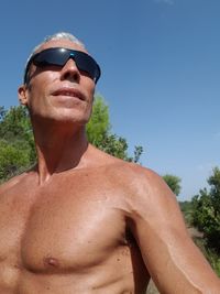 Shirtless man standing against clear blue sky