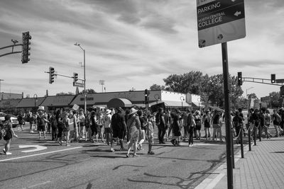 People on street in city against sky