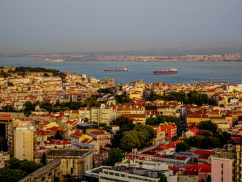 High angle view of townscape by sea against sky